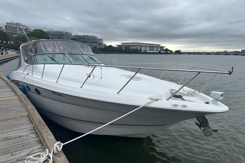 Slide: The Image of 2004 Larson 370 boat docked by a wooden pier on a cloudy day. - 1