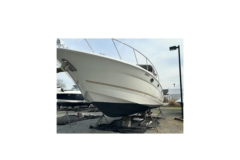 Slide: The Image of 2004 Larson 370 boat on dry dock, side view with clear sky background. - 10