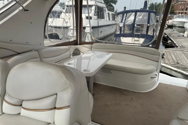 Slide: The Image of Interior of a 2004 Larson 370 yacht with white seating and table. - 4