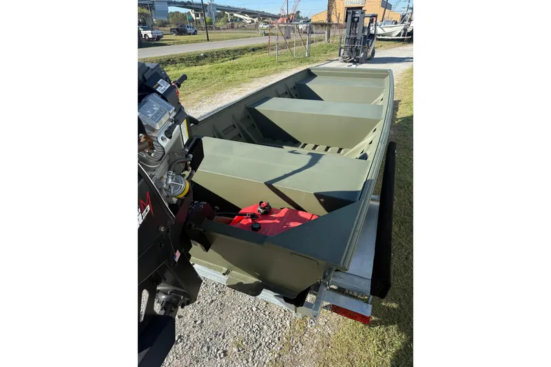 Slide: The Image of 2025 Alweld 1442 DS boat interior with motor, parked on grass. - 3