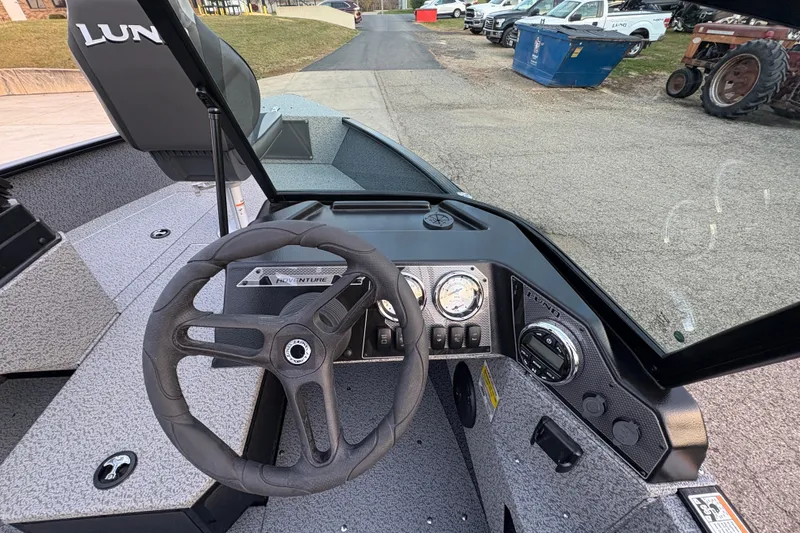 Slide: The Image of 2026 Lund 1775 Adventure Sport boat dashboard with steering wheel and gauges. - 16