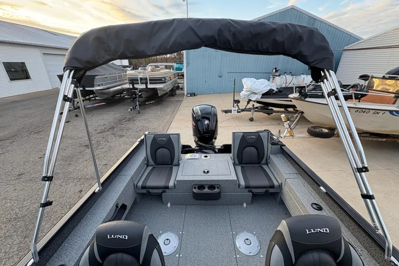 Slide: The Image of 2026 Lund 1775 Adventure Sport boat with seating and canopy in a marina setting. - 25