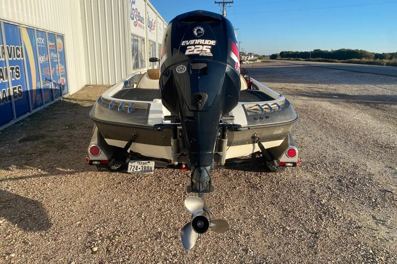 Slide: The Image of 2006 Ranger Z20 Comanche boat with Evinrude 225 motor, parked on gravel near dealership. - 4