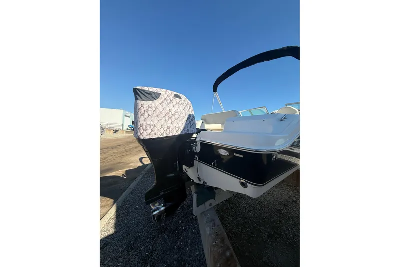 Slide: The Image of 2007 NauticStar 2000 DC Offshore boat with covered outboard motor, parked on gravel. - 3