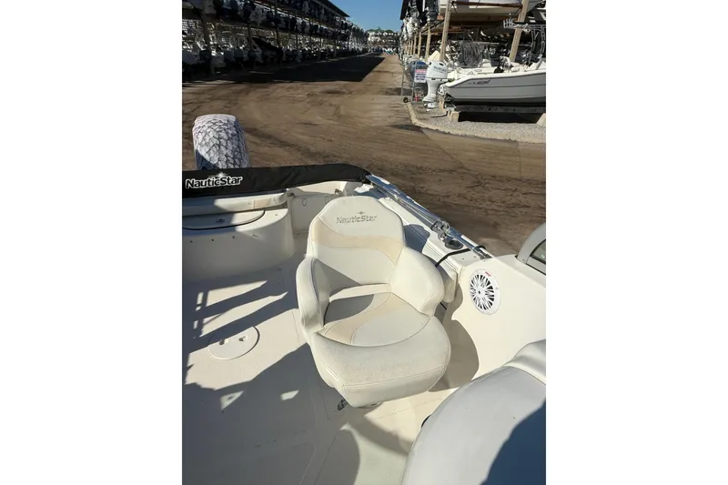 Slide: The Image of 2007 NauticStar 2000 DC Offshore boat interior with seating and speaker, docked at marina. - 8