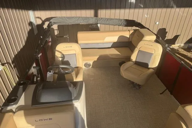 Slide: The Image of 2026 Lowe LS 170 boat interior with beige seating and steering console. - 17