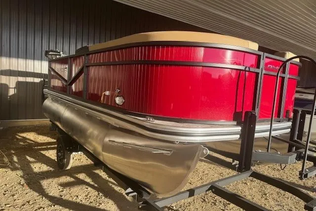 Slide: The Image of 2026 Lowe LS 170 pontoon boat with red exterior, parked indoors. - 2