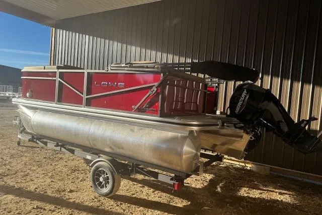 Slide: The Image of 2026 Lowe LS 170 pontoon boat with red panels and outboard motor on trailer. - 5