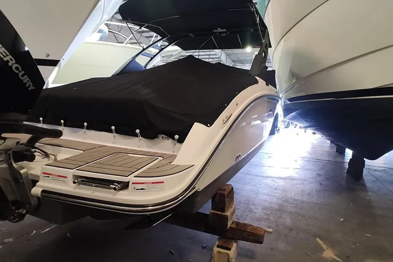 Slide: The Image of 2025 Sea Ray SDX 270 Outboard boat in storage, covered and elevated on blocks. - 2