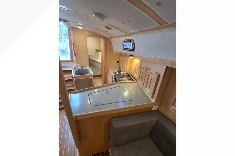 Slide: The Image of Interior of 2018 Tartan 345 yacht featuring a compact kitchen and seating area. - 12