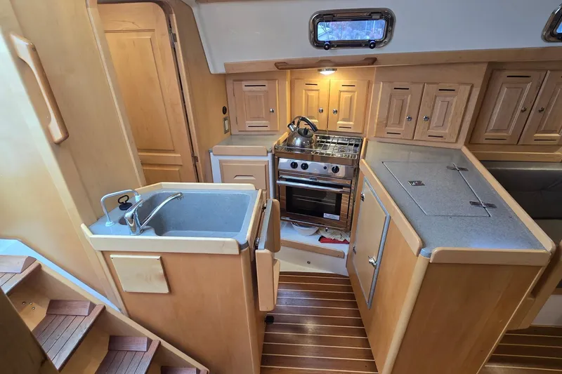 Slide: The Image of Compact kitchen in 2018 Tartan 345 yacht with wooden cabinetry and modern appliances. - 13