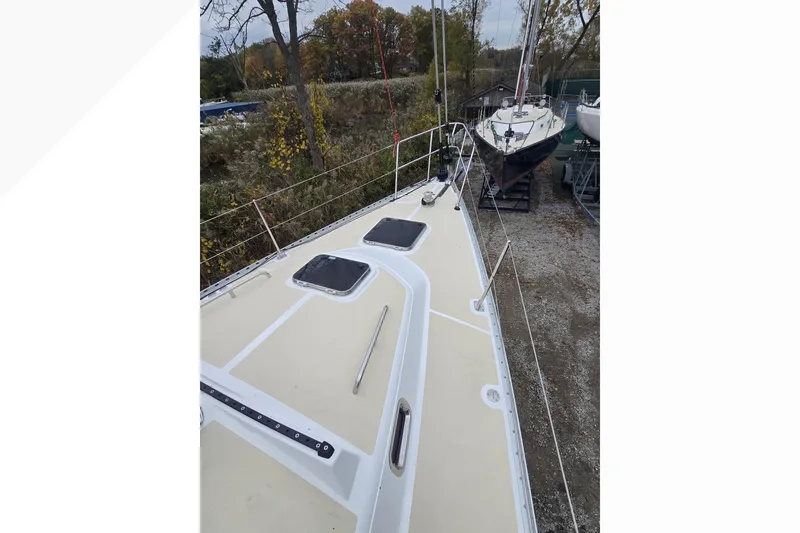 Slide: The Image of 2018 Tartan 345 sailboat on land, showcasing deck and surrounding trees. - 35