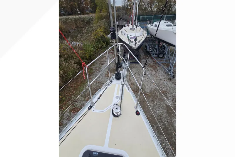 Slide: The Image of Tartan 345 sailboat deck, 2018 model, docked with surrounding greenery and other boats. - 40