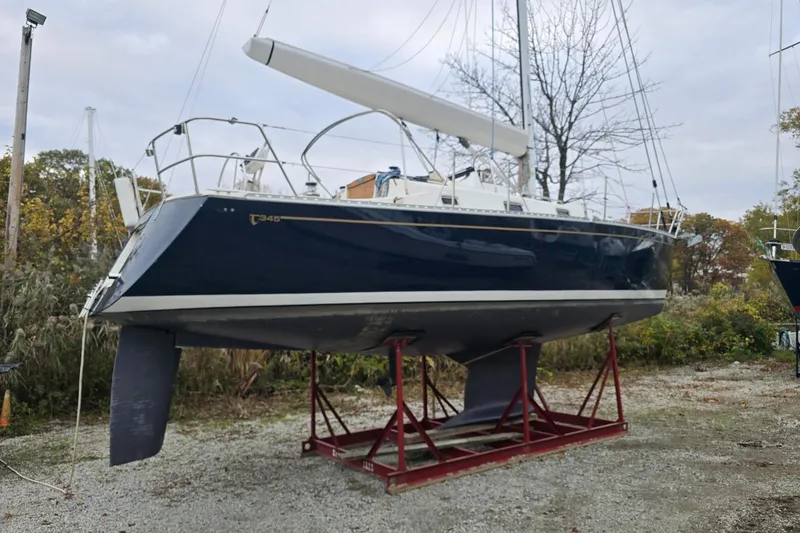 Slide: The Image of 2018 Tartan 345 sailboat on a stand, outdoors, with trees in the background. - 6