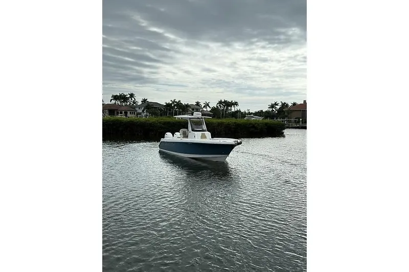 The Image of 2022 Edgewater 262CC boat on calm water with cloudy sky backdrop. - 10
