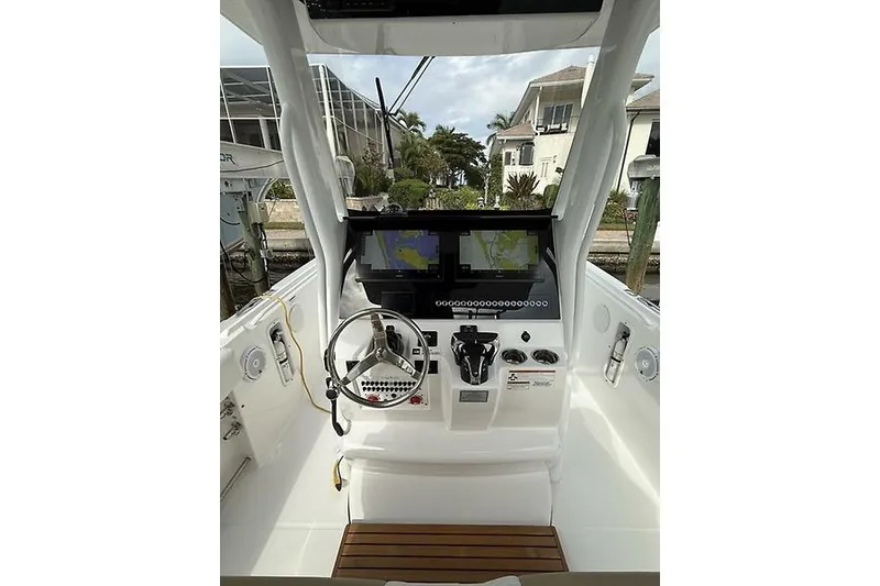 Slide: The Image of 2022 Edgewater 262CC boat cockpit with steering wheel and navigation screens. - 13