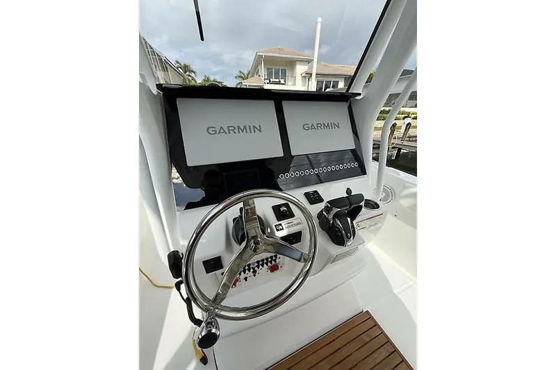 Slide: The Image of 2022 Edgewater 262CC boat dashboard with dual Garmin displays and steering wheel. - 14