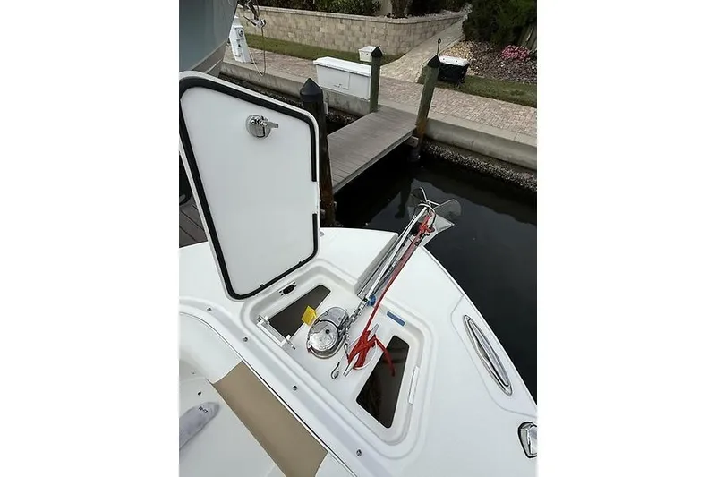 Slide: The Image of 2022 Edgewater 262CC boat with open storage compartment at dockside. - 20