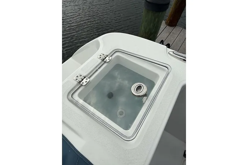 Slide: The Image of 2022 Edgewater 262CC boat livewell with clear lid, dockside view. - 25