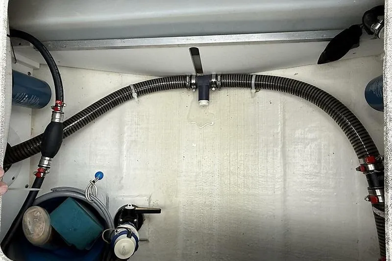 Slide: The Image of 2022 Edgewater 262CC boat interior showing hoses and equipment in storage compartment. - 29