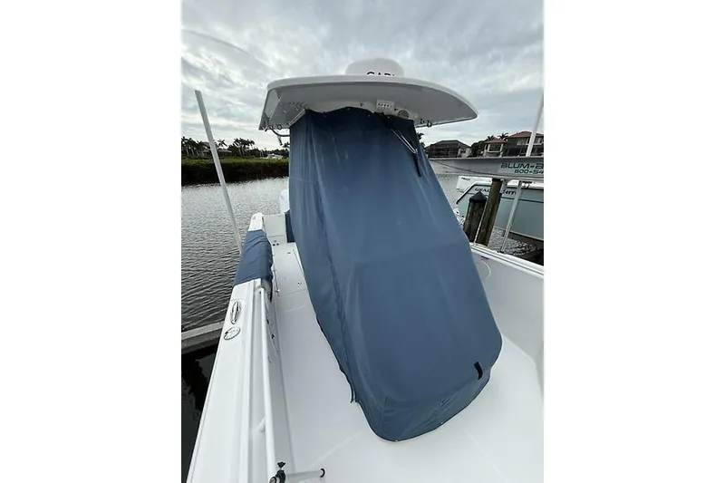 Slide: The Image of 2022 Edgewater 262CC boat with covered console, docked by the water. - 33