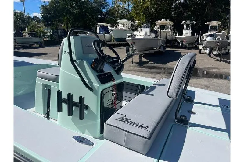 Slide: The Image of 2026 Maverick 18 HPX-V boat, light blue, parked outdoors near a fence and building. - 5