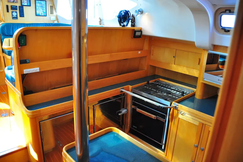 Slide: The Image of Interior of 2000 Custom Steel Cutter World Cruiser yacht kitchen with wooden cabinetry and stove. - 19