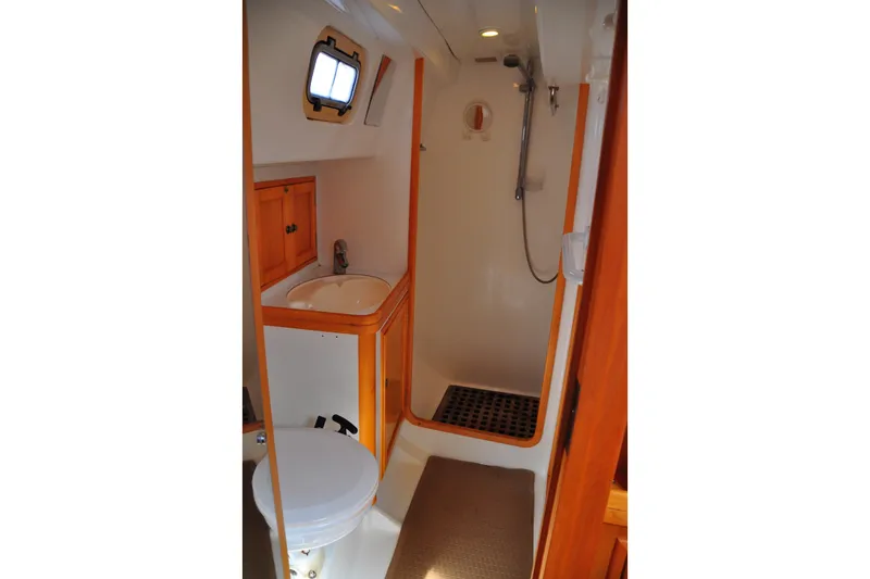 Slide: The Image of Compact bathroom in 2000 Custom Steel Cutter World Cruiser yacht, featuring shower, sink, and toilet. - 20