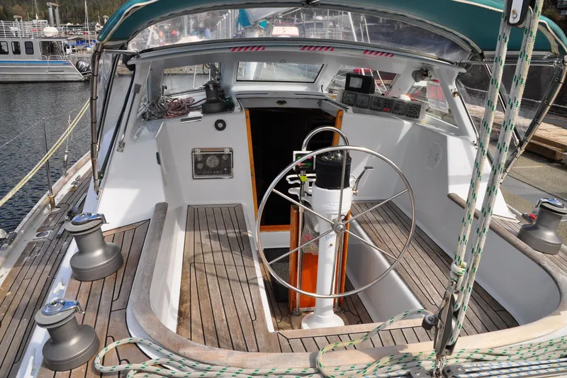 Slide: The Image of Cockpit of 2000 Custom Steel Cutter World Cruiser sailboat with wooden deck and steering wheel. - 24