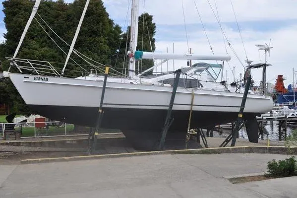Slide: The Image of Custom Steel Cutter World Cruiser 2000 sailboat on dry dock, marina background. - 31
