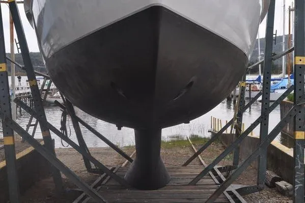 Slide: The Image of Custom Steel Cutter World Cruiser 2000 on dry dock, showcasing hull and keel design. - 32