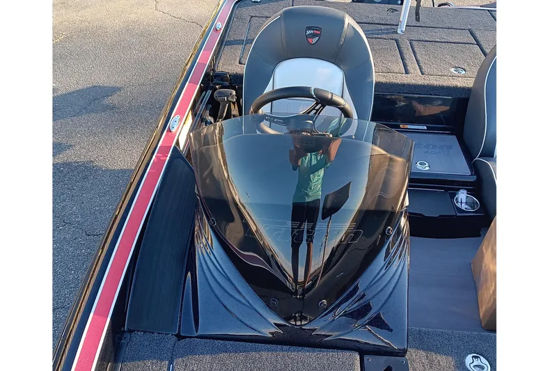 Slide: The Image of 2026 Triton 18 TrX boat cockpit with steering wheel and seating, featuring sleek design. - 11