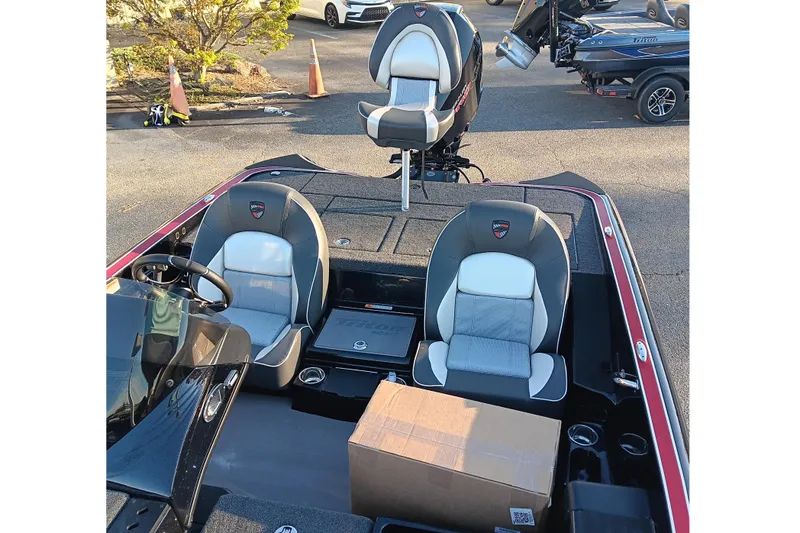 Slide: The Image of 2026 Triton 18 TrX boat interior with seating and steering wheel, parked outdoors. - 13