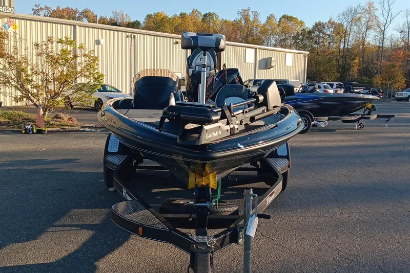 Slide: The Image of 2026 Triton 18 TrX boat on trailer in parking lot, surrounded by autumn trees. - 7