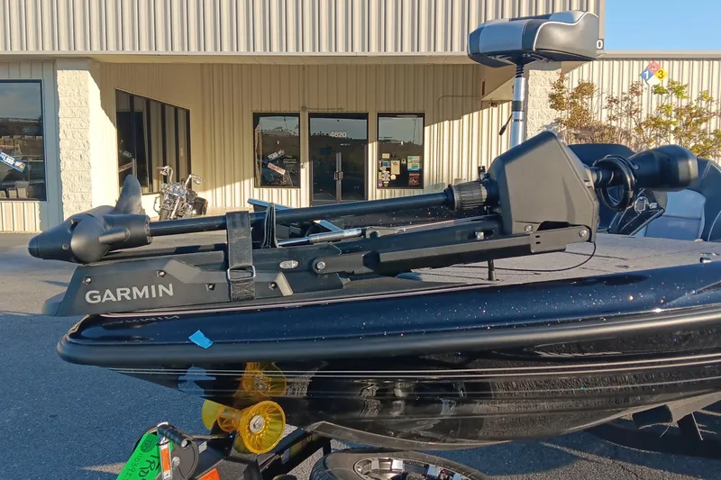 Slide: The Image of 2026 Triton 18 TrX boat with Garmin trolling motor in front of a building. - 8