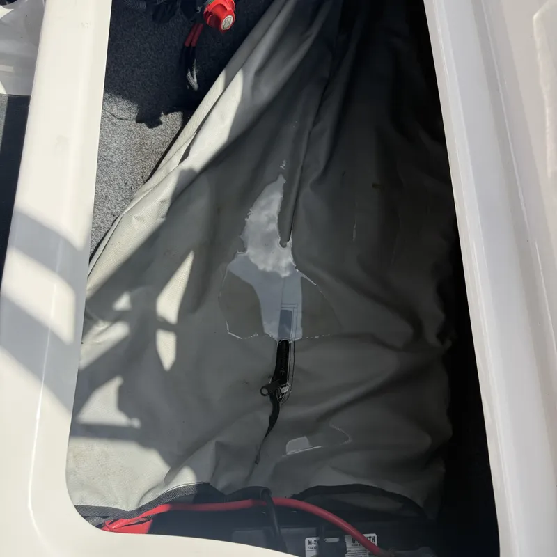 Slide: The Image of A storage compartment in the boat with a gray cover and cables. - 25