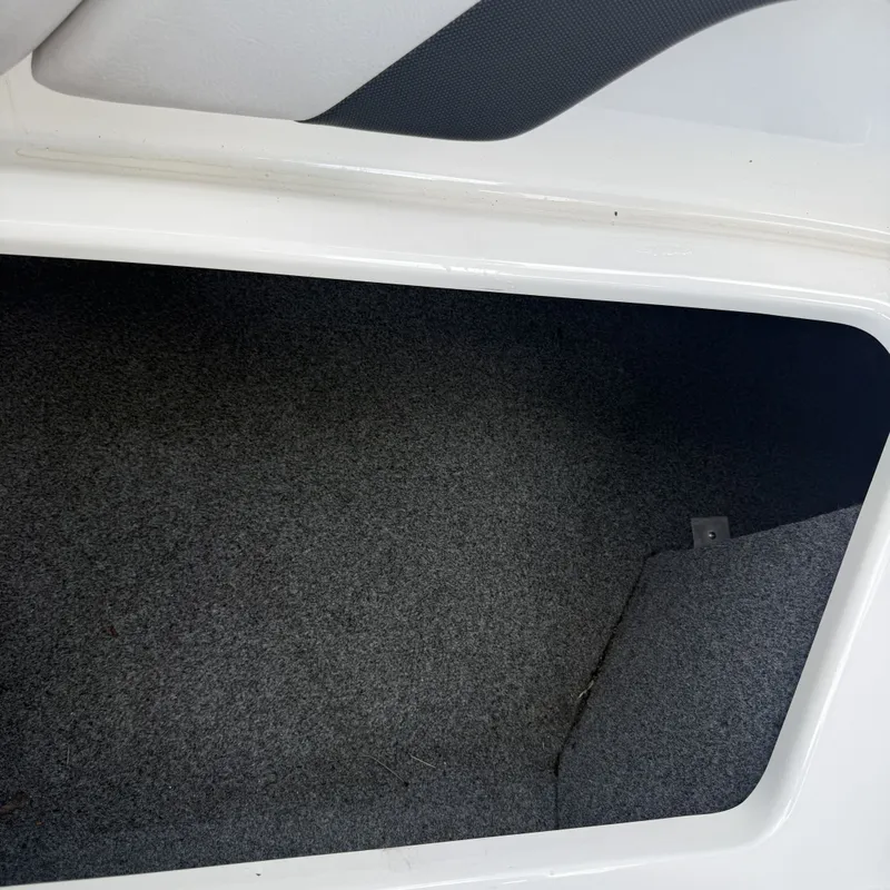 Slide: The Image of An empty storage compartment with gray carpet lining inside a boat. - 27