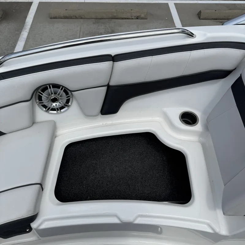 Slide: The Image of The image shows the seating area of a 2014 Yamaha 212X boat with a speaker and storage space. - 24