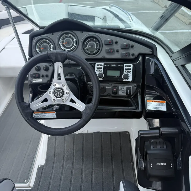 Slide: The Image of The image shows the cockpit of a 2014 Yamaha 212X boat with steering wheel and dashboard. - 17