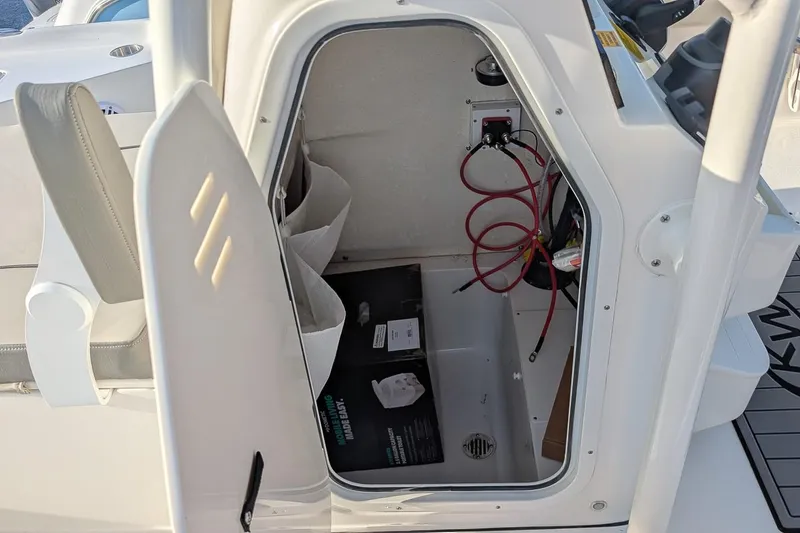 Slide: The Image of Open storage compartment on 2026 Key West 250 Bay Reef boat, showing interior equipment and wiring. - 14