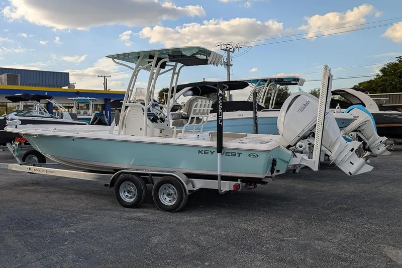 Slide: The Image of 2026 Key West 250 Bay Reef boat on trailer, displayed outdoors under blue sky. - 2