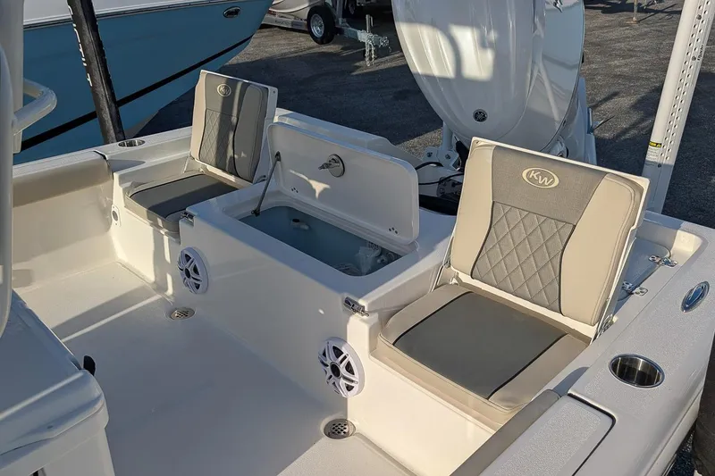 Slide: The Image of 2026 Key West 250 Bay Reef boat interior with cushioned seats and storage compartments. - 8
