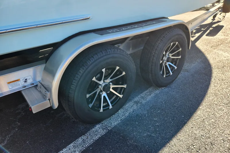 Slide: The Image of Trailer wheels of a 2026 BlackJack 224 boat on asphalt. - 19