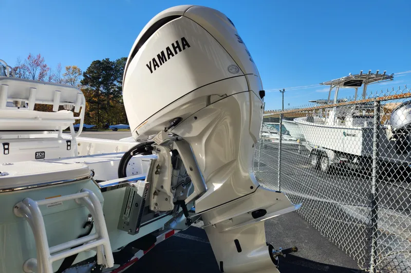 Slide: The Image of 2026 BlackJack 224 boat with Yamaha outboard motor, parked near a fence. - 4