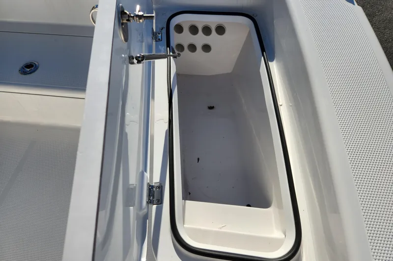 Slide: The Image of Open storage compartment on 2026 BlackJack 224 boat, featuring drainage holes. - 9