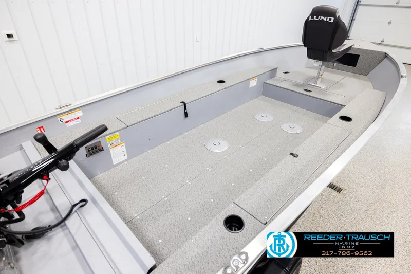 Slide: The Image of 2026 Lund 1600 Fury Tiller boat interior with seating and controls in showroom. - 11