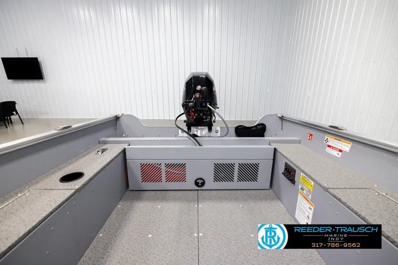 Slide: The Image of 2026 Lund 1600 Fury Tiller boat interior with motor, showcased in a showroom. - 17