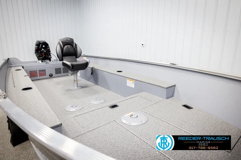 Slide: The Image of 2026 Lund 1600 Fury Tiller boat interior with seating and motor, displayed indoors. - 19