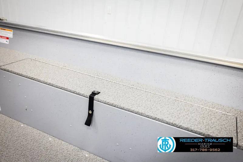 Slide: The Image of 2026 Lund 1600 Fury Tiller boat interior with storage compartment and safety strap. - 20