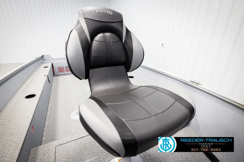 Slide: The Image of 2026 Lund 1600 Fury Tiller boat seat, black and gray design, in showroom setting. - 27
